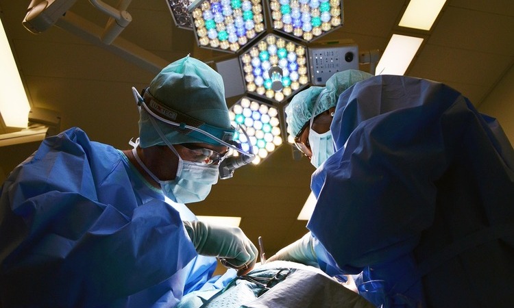 Surgeons perform an operation in a hospital operating room as rising healthcare costs leave many Americans reluctant to leave jobs with employer-sponsored health insurance.
